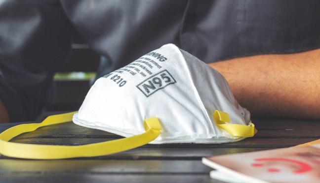 closeup N95 air filter mask. personal protective equipment in office with soft-focus and over light in the background